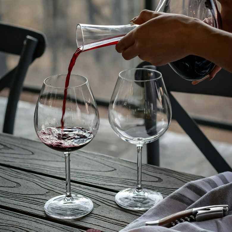 Wijnproeverij. Wijn wordt uitgeschonken uit een karaf.